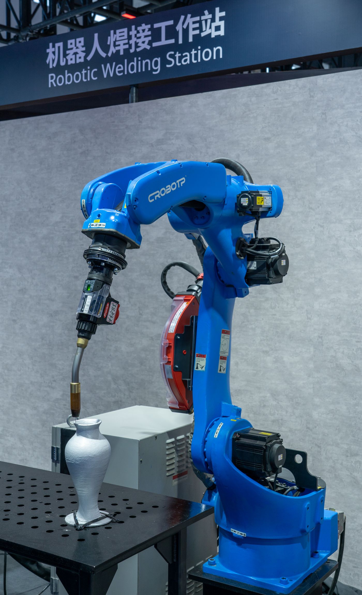 Industrial robot arm on an automated welding station